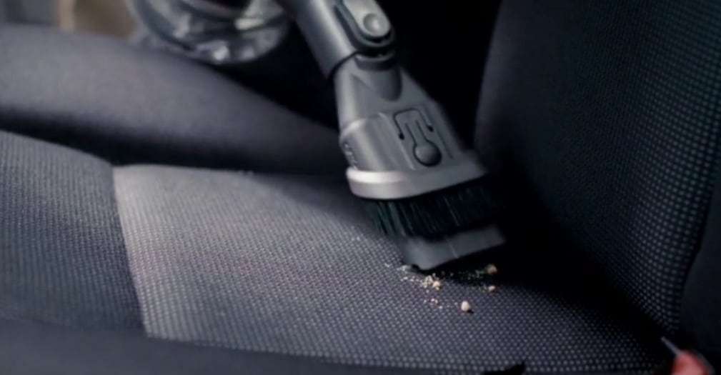 aspiradora succionando migajas en un asiento de coche